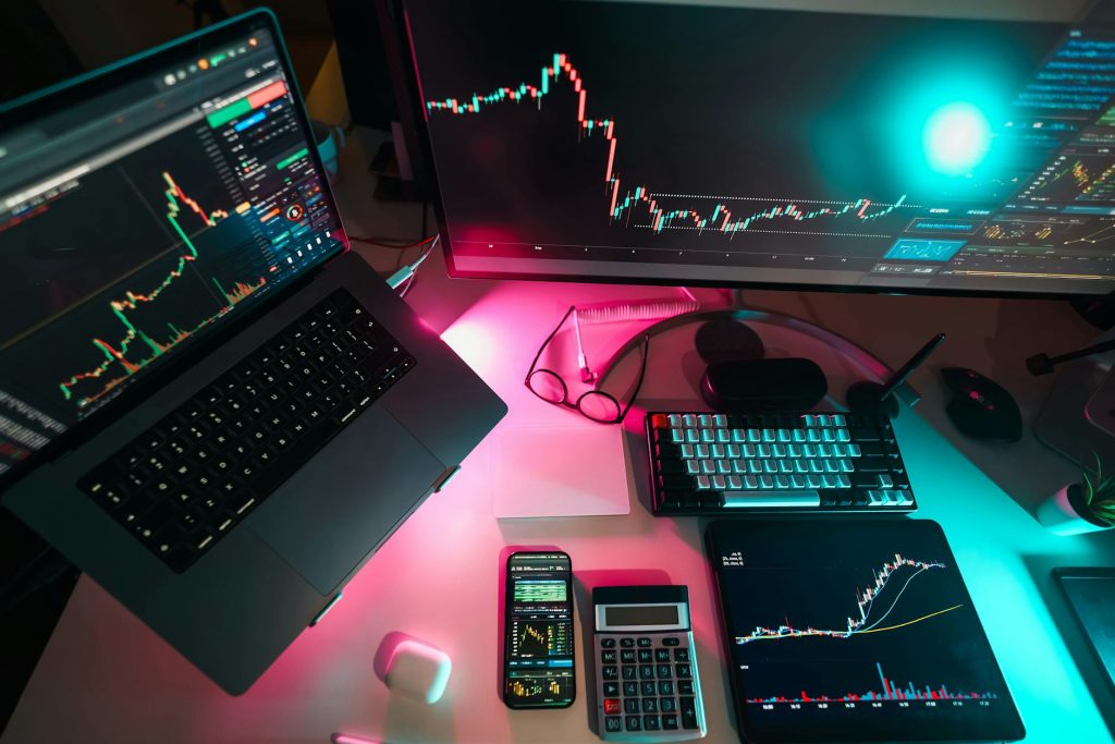 High-tech trading setup featuring digital charts on multiple devices, ideal for finance professionals.