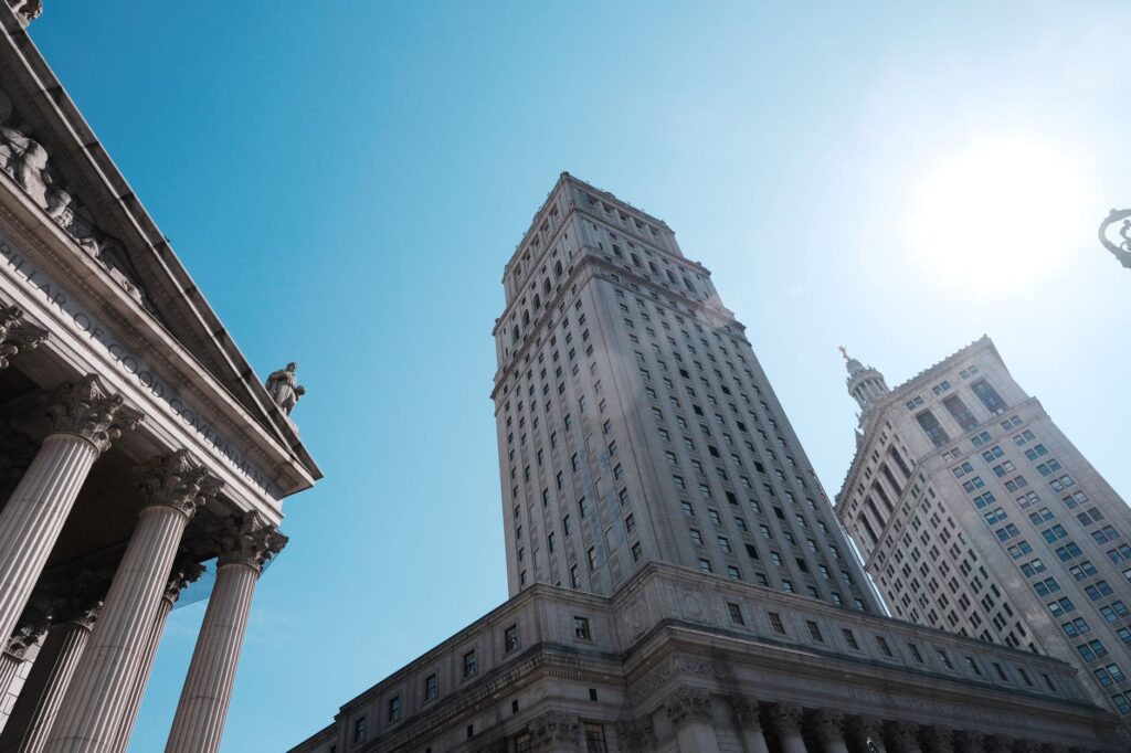 Elevated view of towering skyscrapers and historic architecture against a clear blue sky.