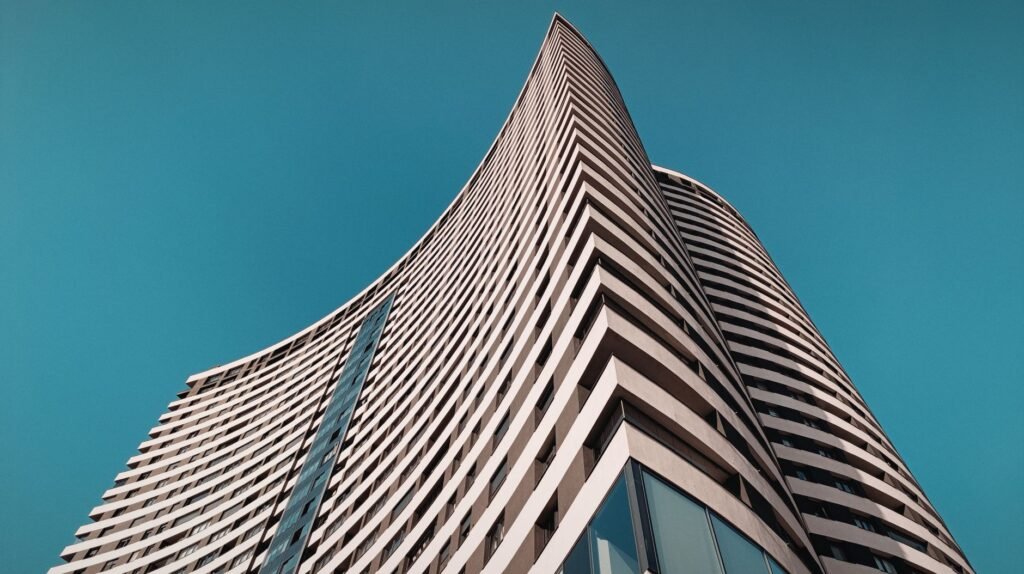 Elegant curved skyscraper in Sarajevo with a vibrant blue sky.