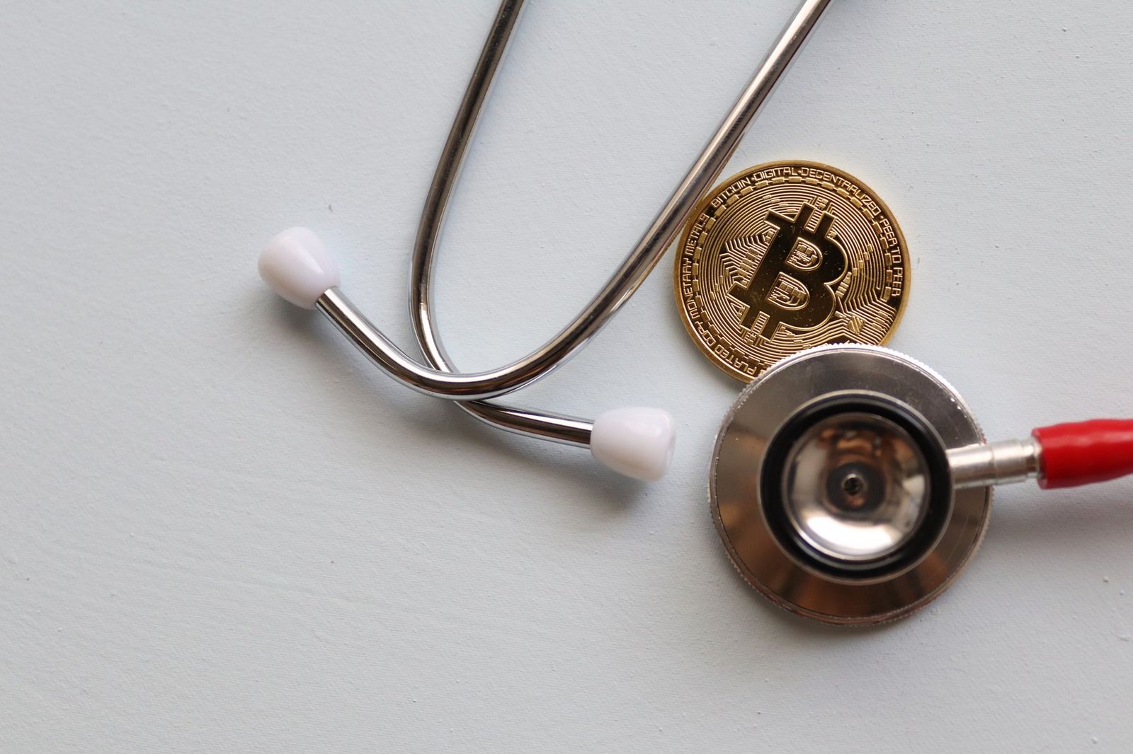 A stethoscope with a Bitcoin coin symbolizing the intersection of healthcare and cryptocurrency.