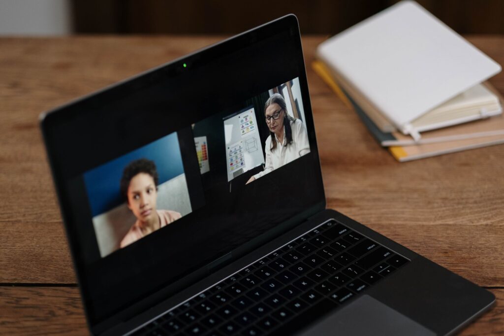 Two people engaging in online education via a laptop, perfect for illustrating virtual learning.