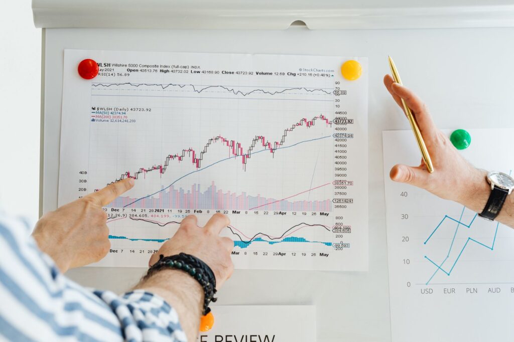 Two professionals analyze stock market graphs with a focus on finance and data trends.