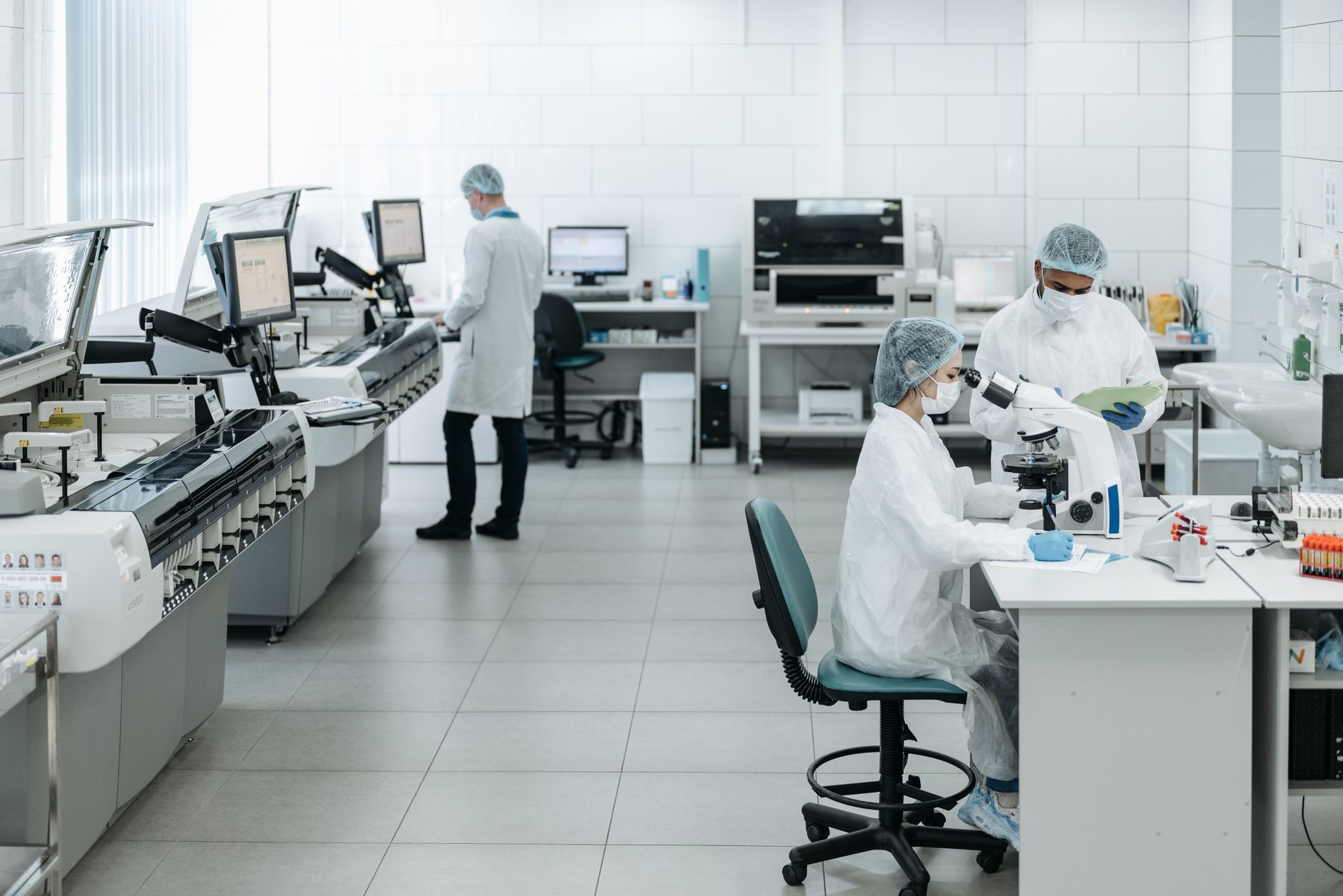 Researchers in lab coats performing experiments with advanced equipment in a laboratory.