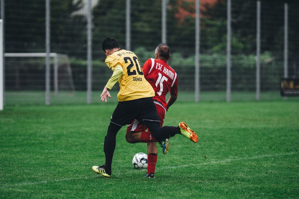 Two soccer players in action on a vibrant green field during a daytime match.