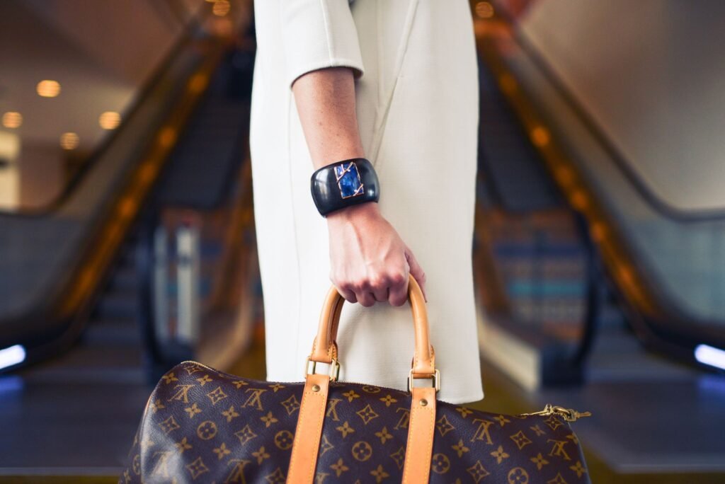 Chic woman with luxury handbag and bracelet in modern shopping environment.