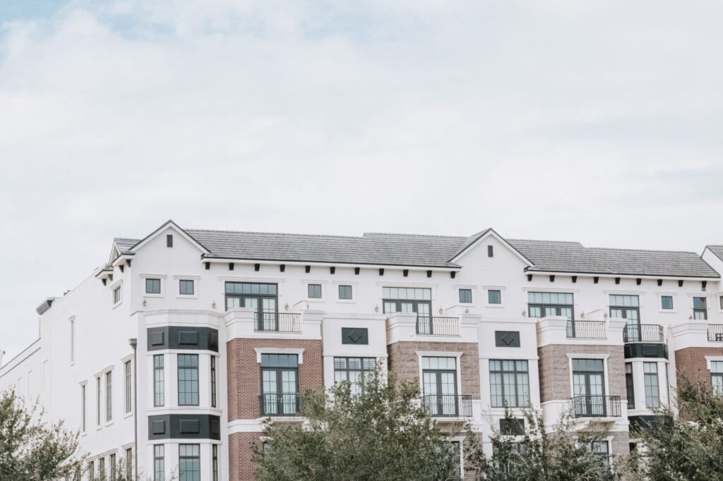 A stylish, multi-story luxury apartment building with a contemporary facade against a clear sky.