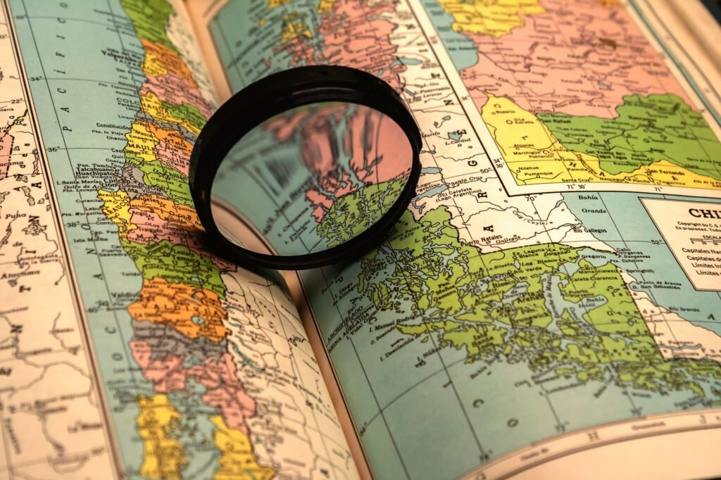 A close-up of a colorful world map with a magnifying glass highlighting details.