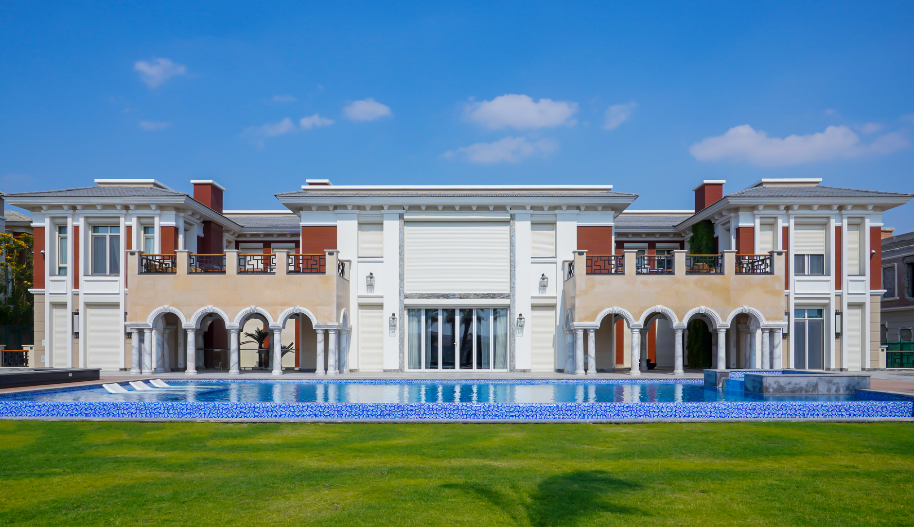Elegant villa with swimming pool and green lawn in Cairo, showcasing luxury architecture.