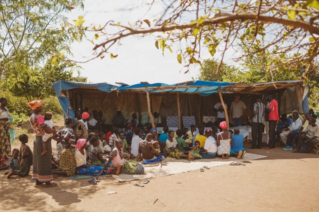 A vibrant community gathering under a tent in Kitgum, Uganda.