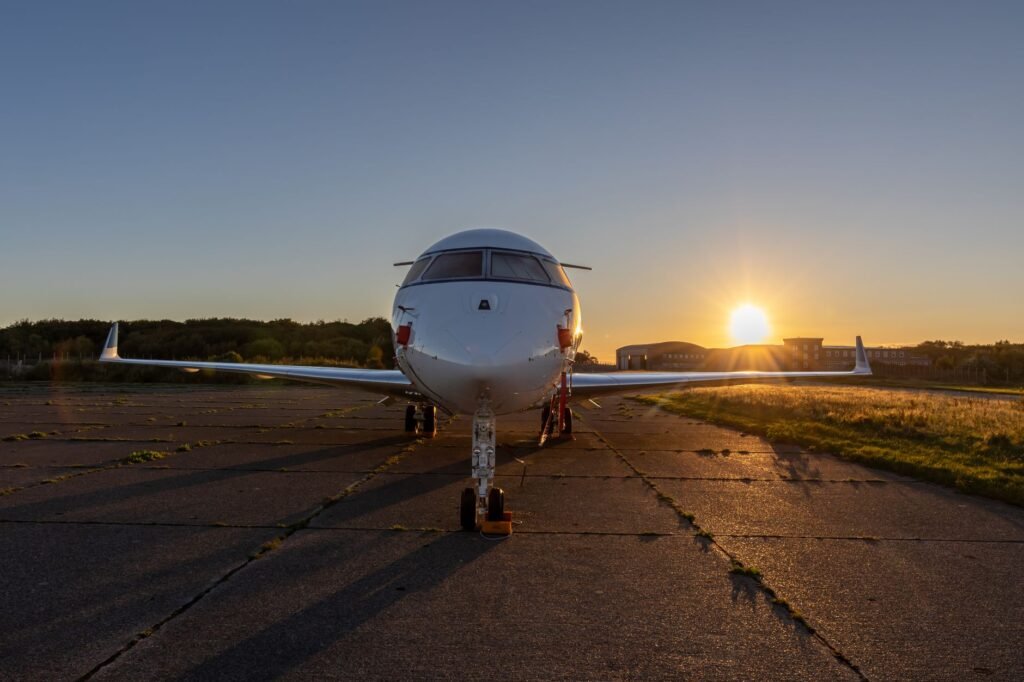 A private jet parked on the runway during a stunning sunset, highlighting the serene aviation scene.