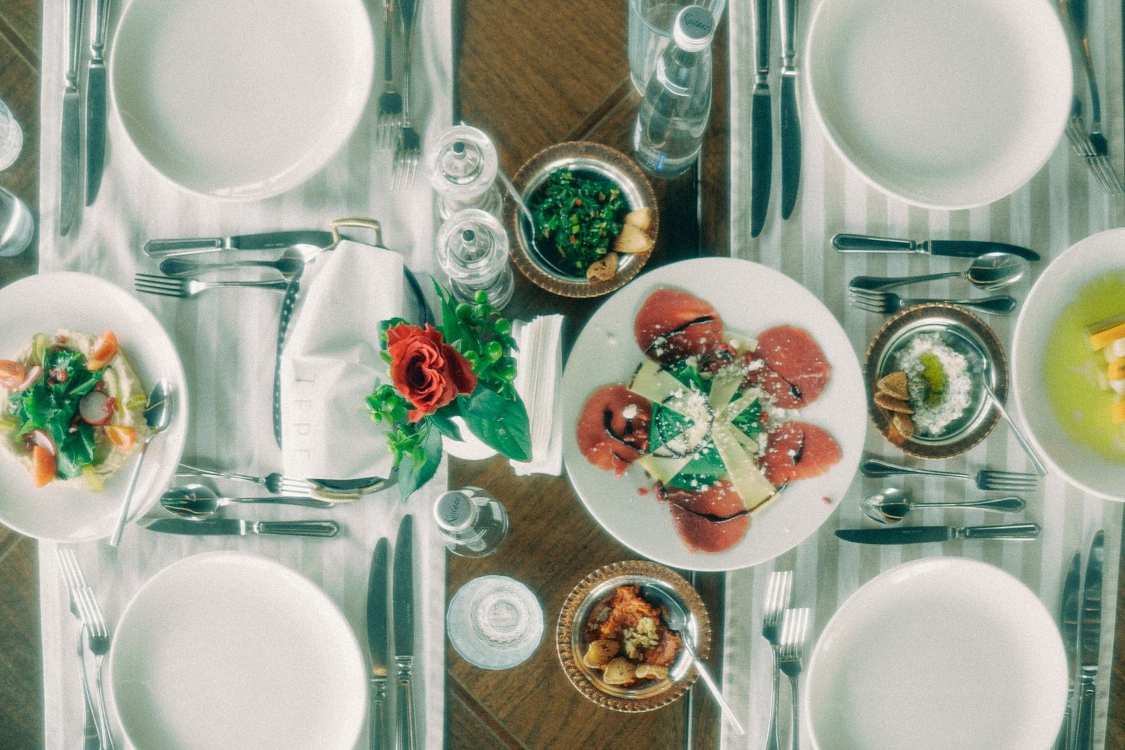 Overhead view of an elegant table setup featuring various gourmet dishes and elegant tableware.