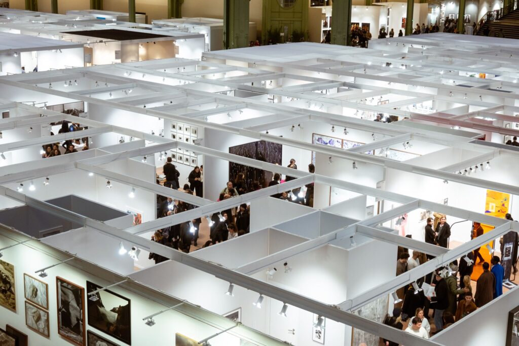 Art exhibition in Paris with people exploring galleries in a modern setup.