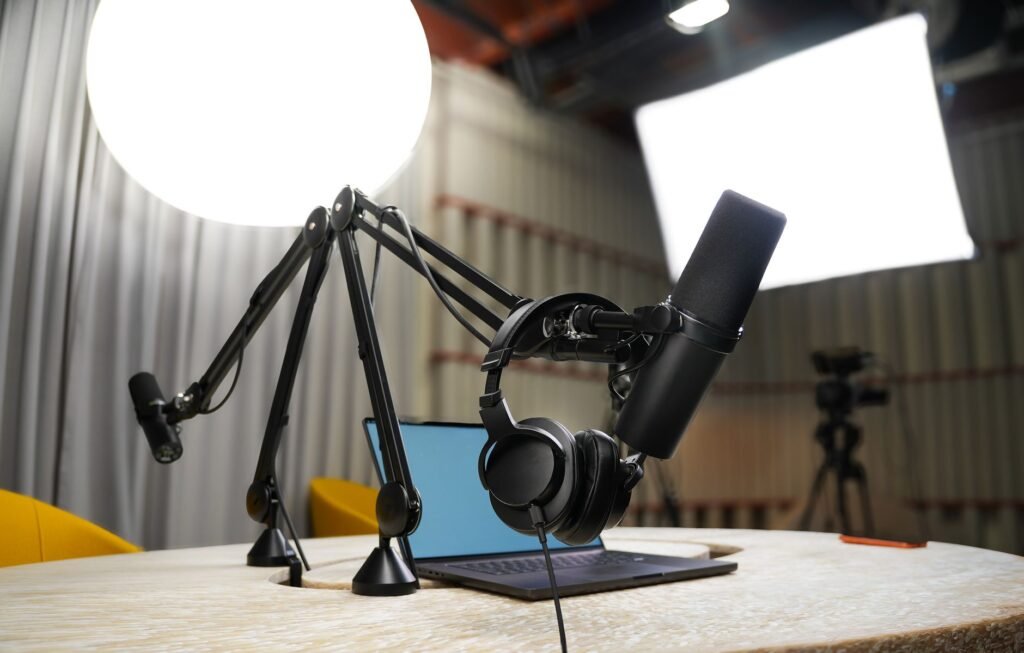 A modern podcast studio with microphone, headphones, and professional lighting for recording sessions.