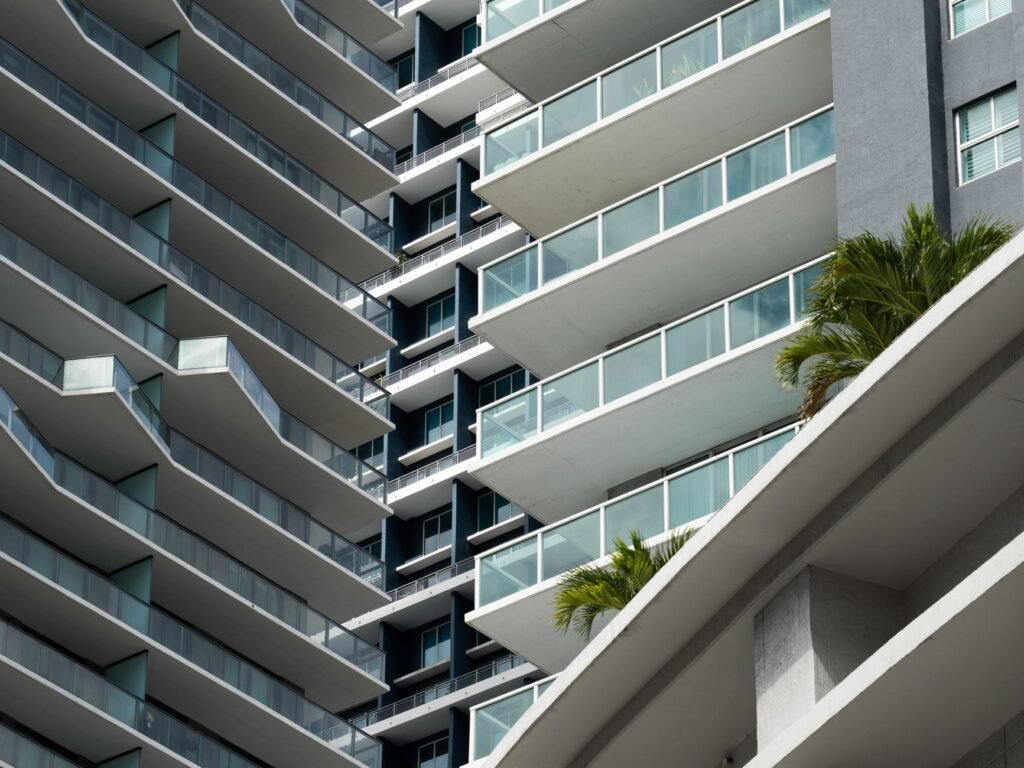 Close-up view of a modern residential building facade in Miami, showcasing sleek lines and expansive balconies.