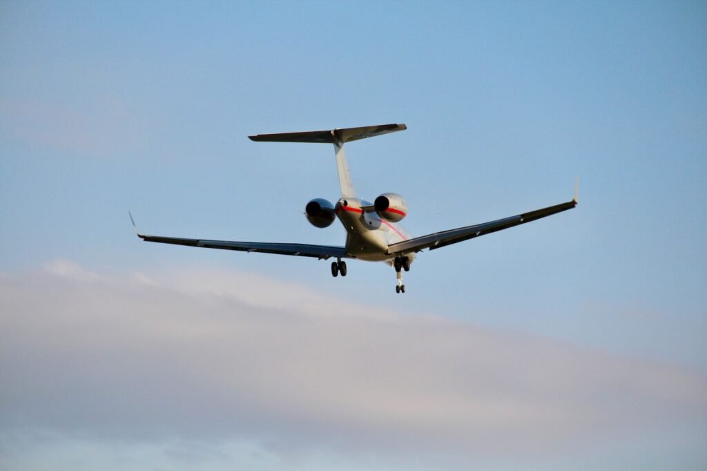 A private jet captured mid-flight with a clear blue sky backdrop, showcasing aviation elegance.