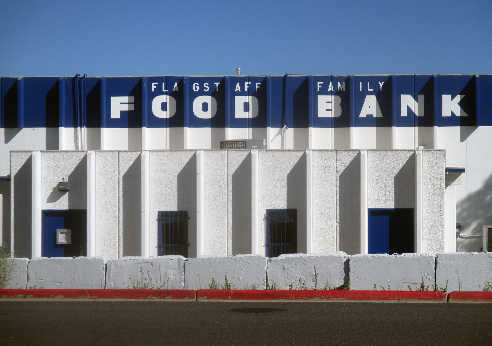 Modern food bank building exterior with bold blue and white design in Flagstaff.