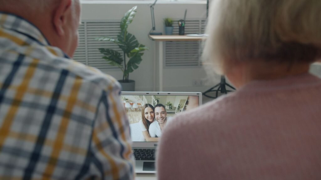 Senior couple having a video chat with family on a laptop indoors.