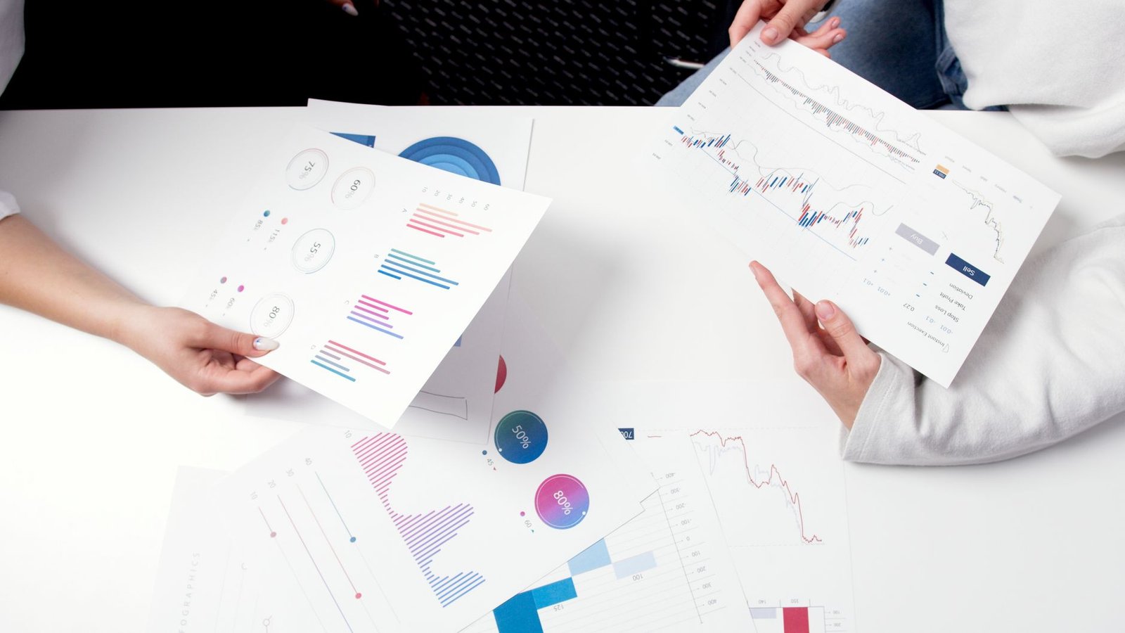 Hands holding business charts and graphs during a meeting, showcasing financial analysis and investment strategy.