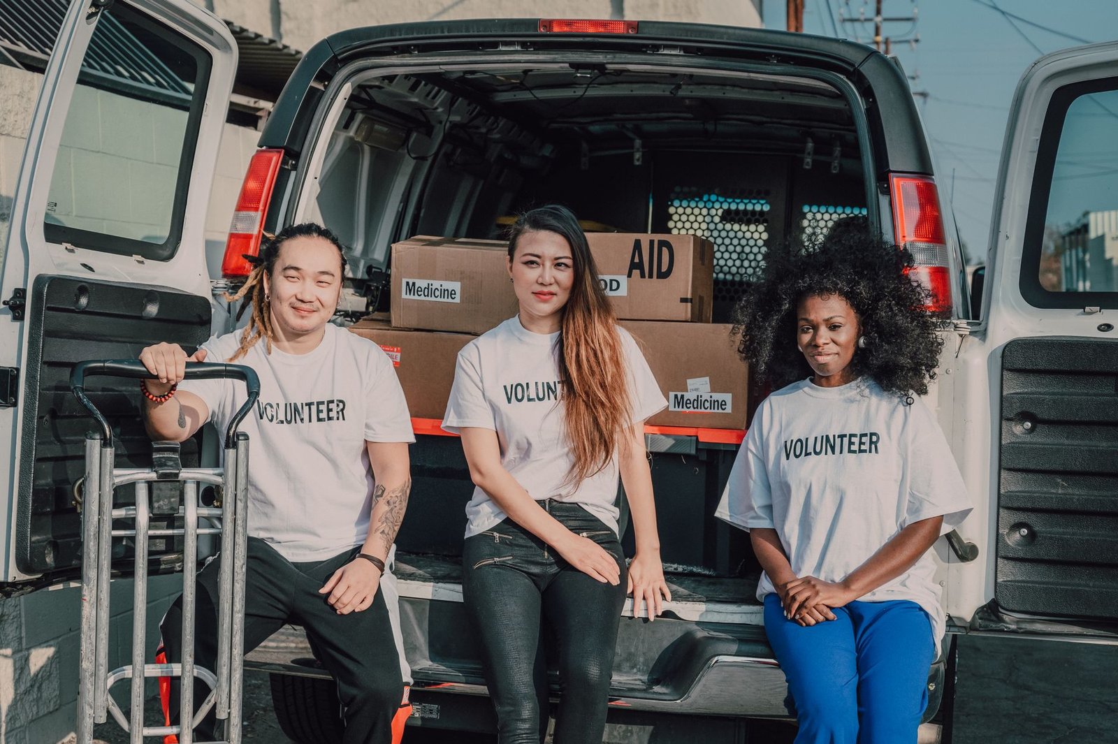 Volunteers organizing medicine and aid supplies for community distribution outdoors.