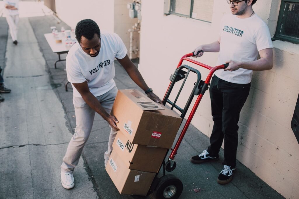 Volunteers move aid boxes for a charity event, emphasizing community support and social impact.