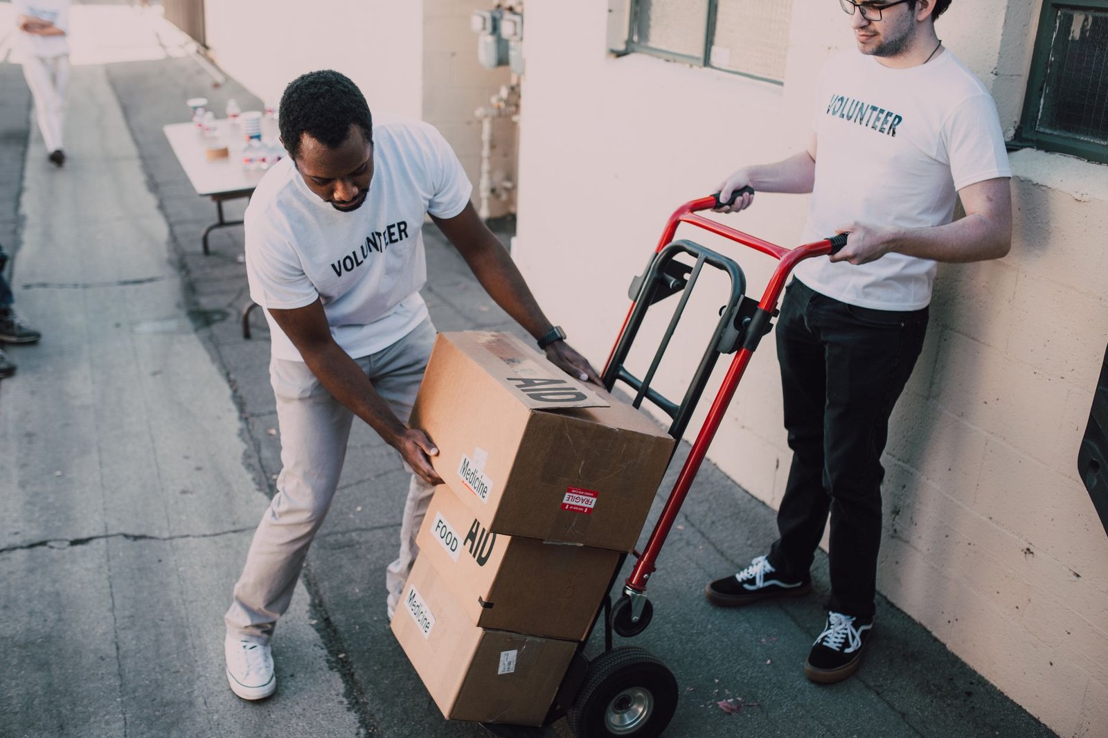 Volunteers move aid boxes for a charity event, emphasizing community support and social impact.