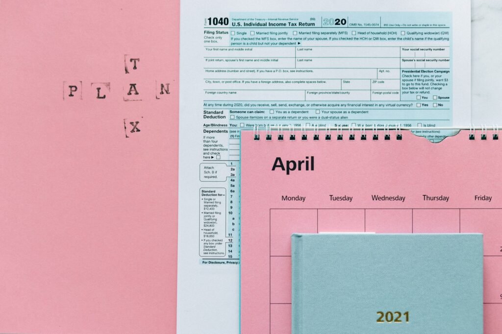 Tax-related items on a pink background, including forms and a calendar.