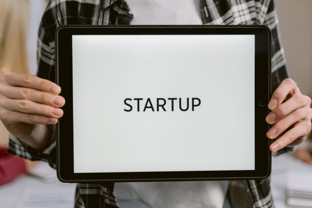 Person holding a digital tablet displaying the word 'STARTUP', representing new business concepts.