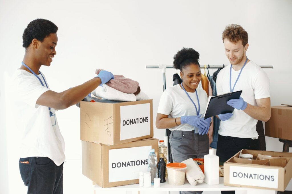 Dedicated volunteers sorting donation boxes indoors for community support.