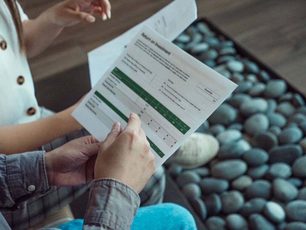 Two people discussing a financial document showing return on investment data.