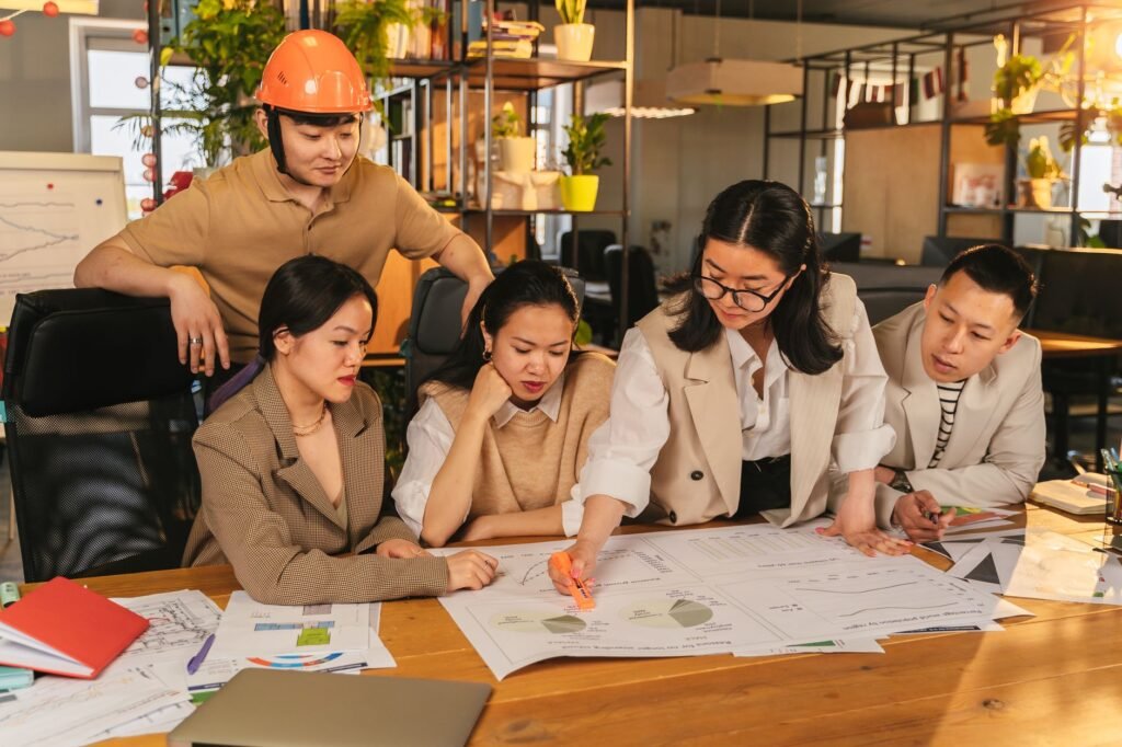 A diverse team of professionals working together on architectural plans in a modern office setting.