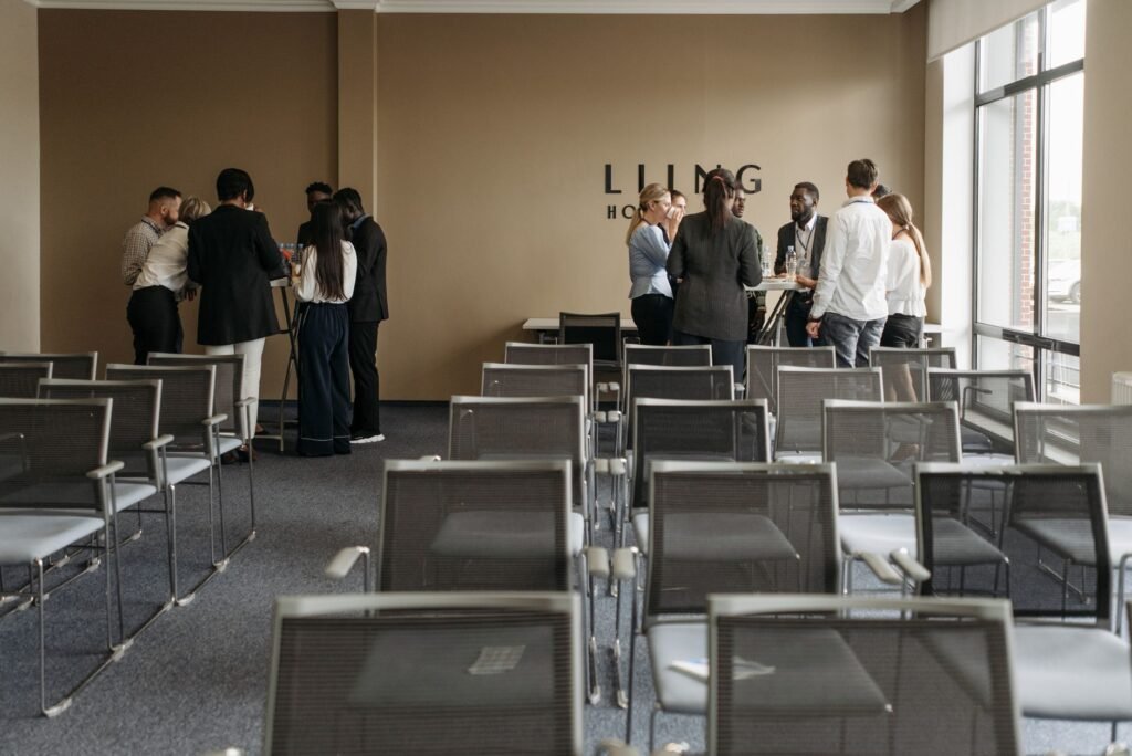 A group discussion taking place in a contemporary conference room with empty chairs.