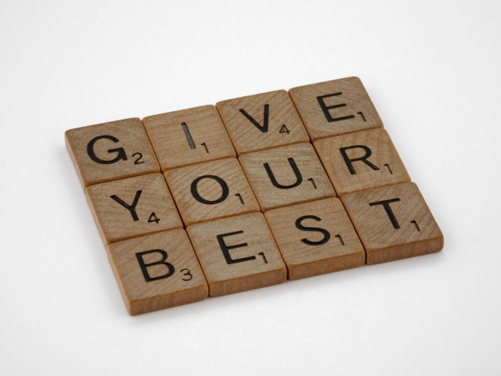 Inspiring message 'Give Your Best' formed with wooden Scrabble tiles.