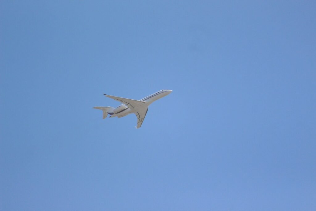 A private jet soars through a clear blue sky, symbolizing luxury air travel.