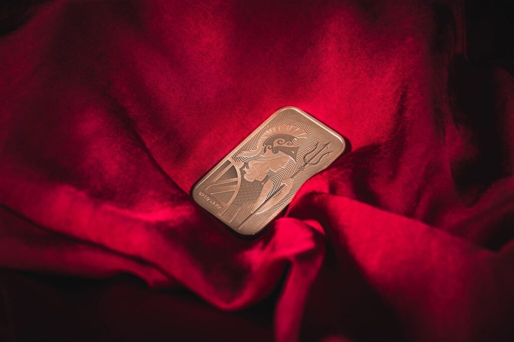 Close-up of a gold bar resting on vibrant red velvet, symbolizing wealth and luxury.