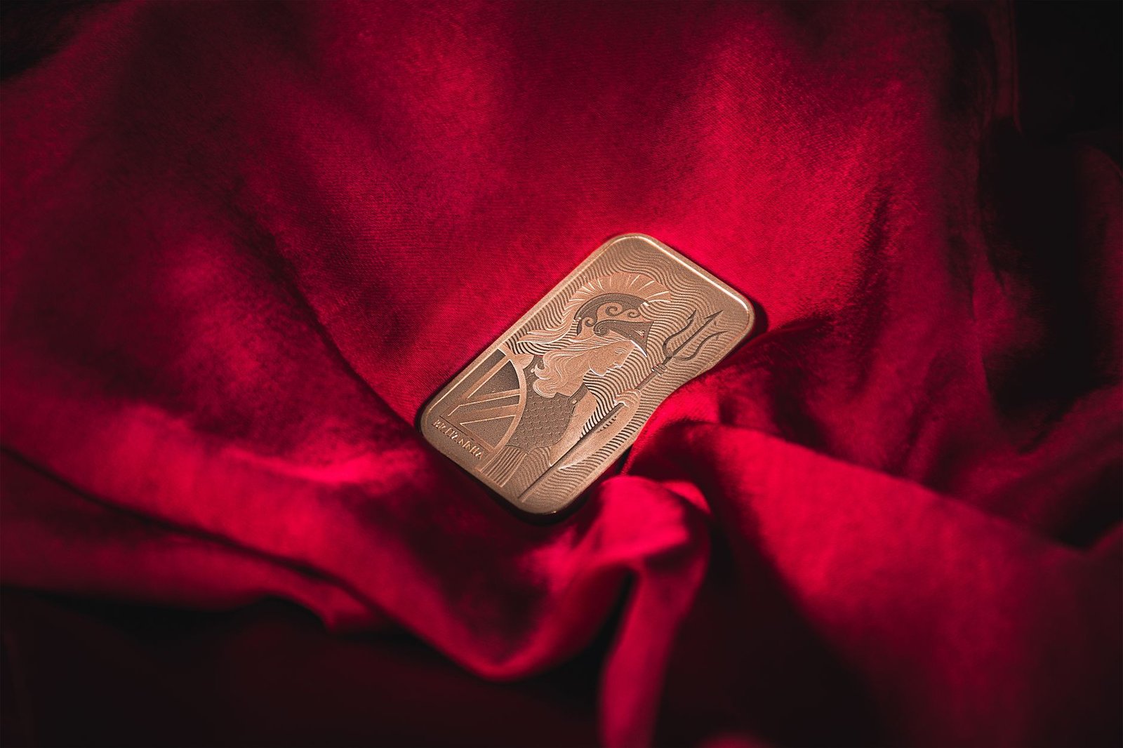 Close-up of a gold bar resting on vibrant red velvet, symbolizing wealth and luxury.