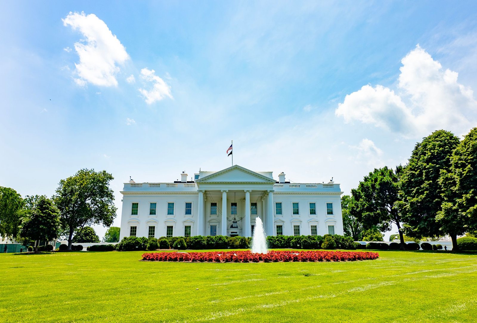 The iconic White House lawn and fountain on a bright summer day in Washington, DC.