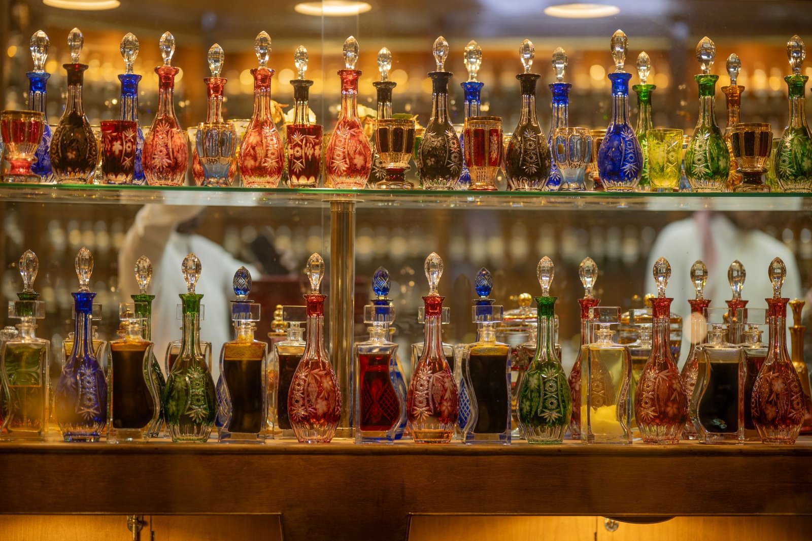 Vibrant display of ornate glass bottles filled with assorted liquids on a shelf indoors.