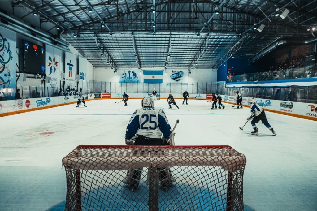 Action-packed ice hockey match with players competing at a Buenos Aires indoor rink. Spectators watch intensively.