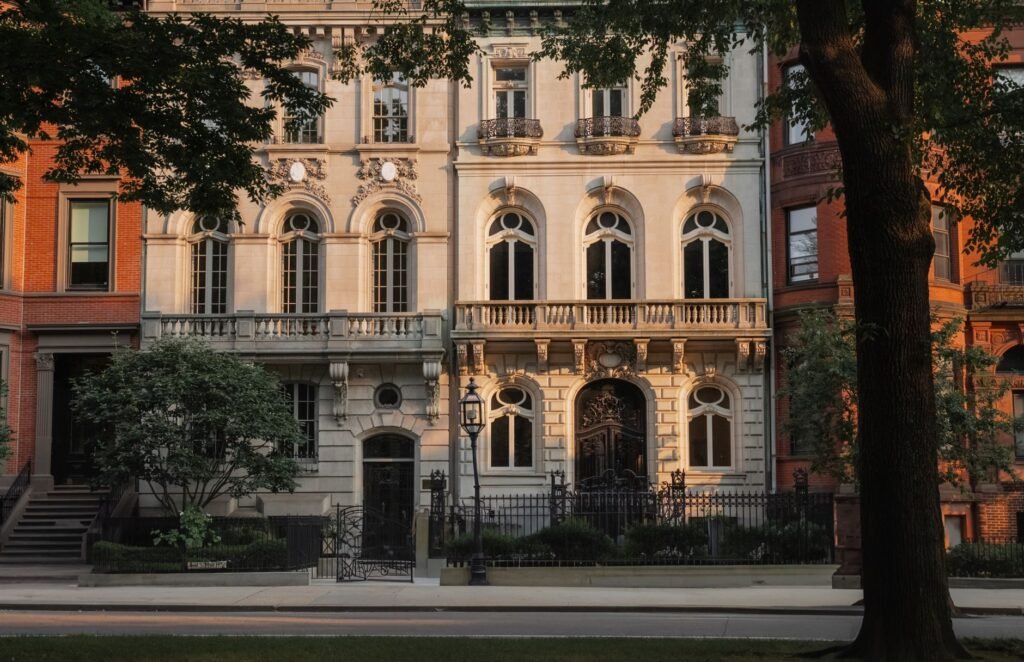 Historic architectural facade basking in sunset light, surrounded by city greenery.
