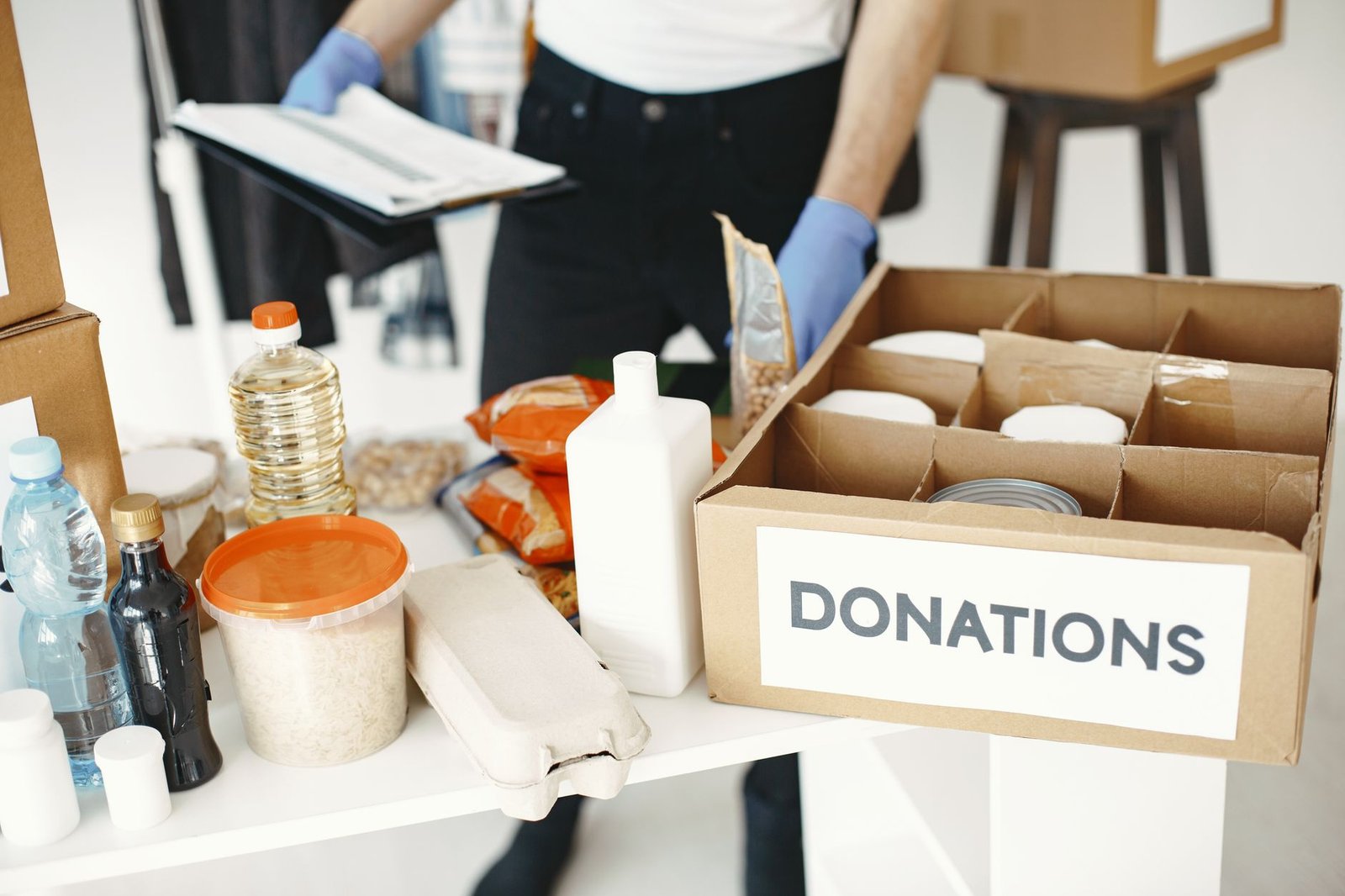 Close-up of donation box with various food items and supplies for community support.
