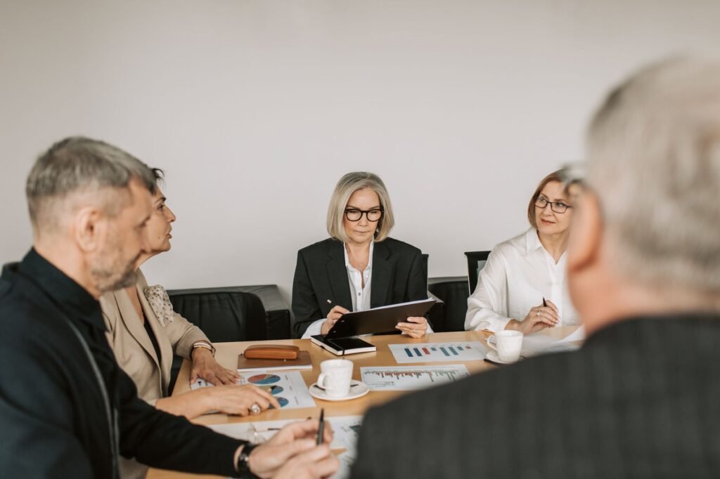 Senior professionals engaged in a collaborative business meeting in a modern office setting.