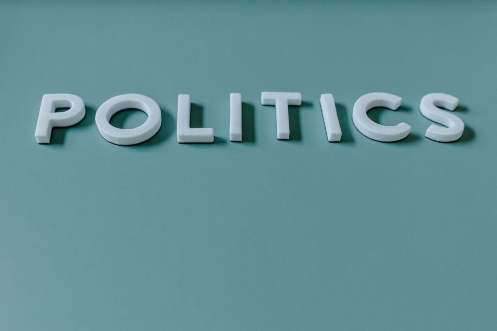 Close-up image of the word 'Politics' against a teal green background, highlighting political themes.