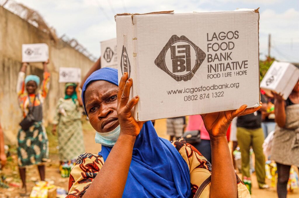 Community members engage in food distribution at Lagos Food Bank initiative event.